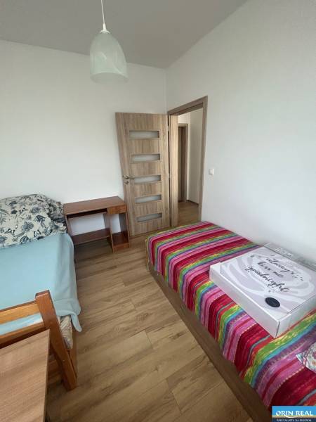 Ein Zimmer mit zwei Betten und einem Tisch in einer 3-Zimmer-Wohnung.