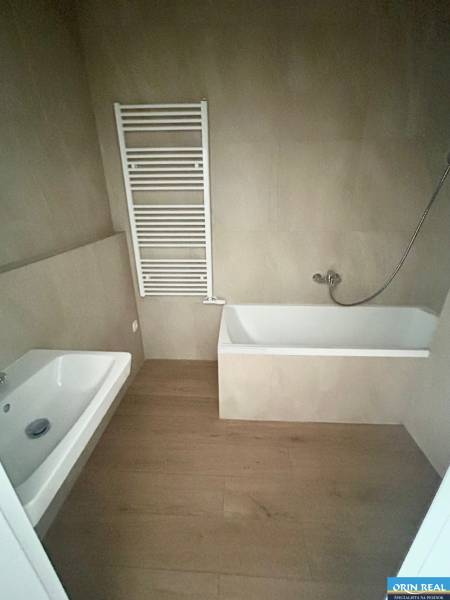 Badezimmer mit Badewanne und Handtuchheizkörper in einer 3-Zimmer-Wohnung, dunkler Boden.