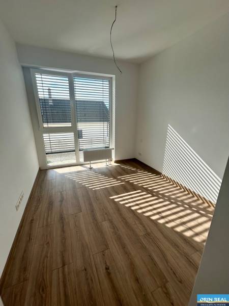 Ein Zimmer in einer 3-Zimmer-Wohnung mit Laminatboden und einem großen Fenster.
