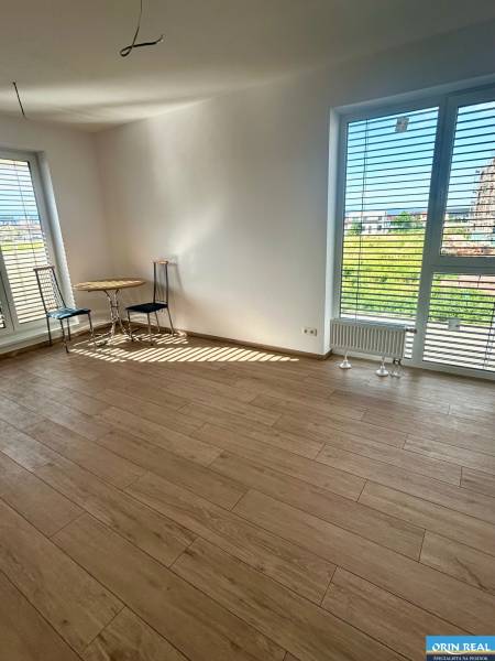 Ein Zimmer in einer 3-Zimmer-Wohnung mit Holzboden und zwei Fenstern mit Aussicht.