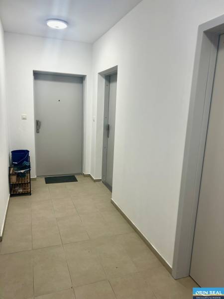 Flur in einer 3-Zimmer-Wohnung mit Türen und Beleuchtung, Fliesen auf dem Boden.