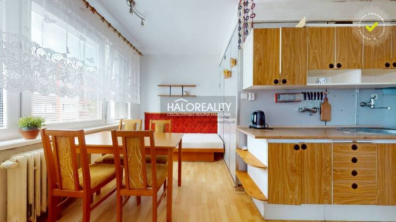 Küche in einer 4-Zimmer-Wohnung mit Holzmöbeln und Esstisch.
