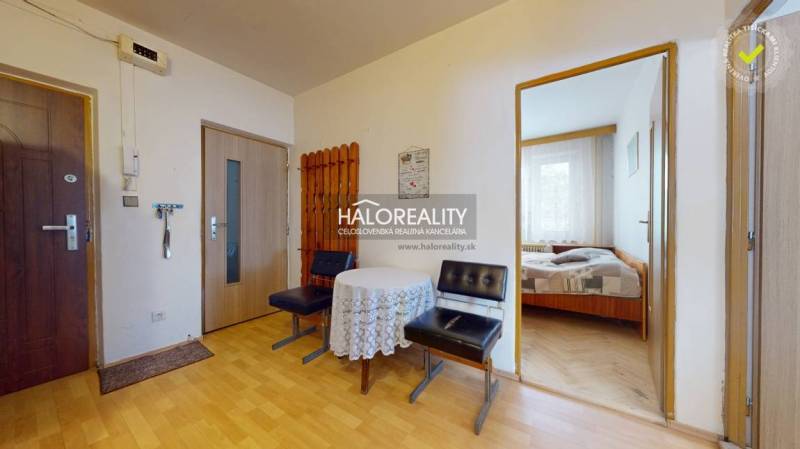 Flur einer 4-Zimmer-Wohnung mit Holzmöbeln, Tisch und Eingang zum Schlafzimmer.