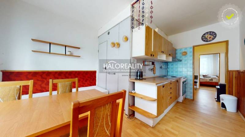 Küche in einer 4-Zimmer-Wohnung mit Holzmöbeln und Esstisch.
