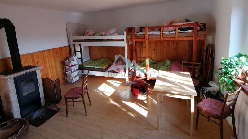 Etagenbetten, Kaminofen und Möbel im Zimmer eines Einfamilienhauses.