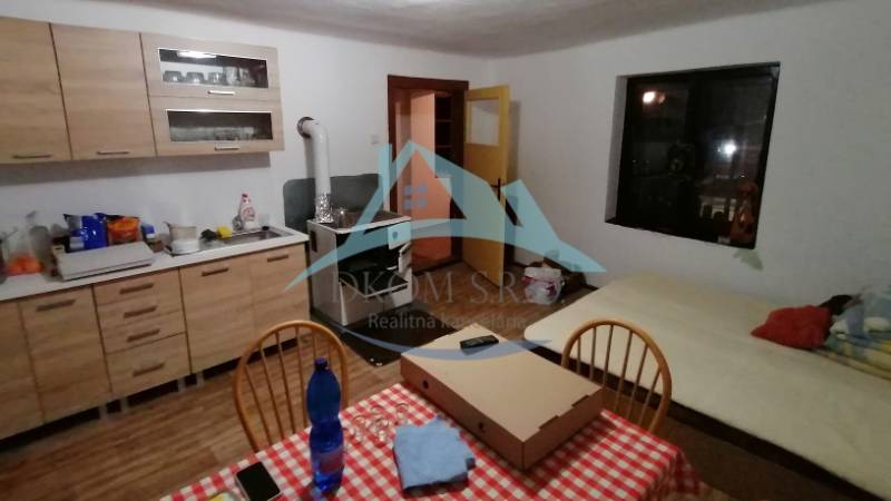 Küche mit Herd, Esstisch und Bett, geeignet für ein Einfamilienhaus.