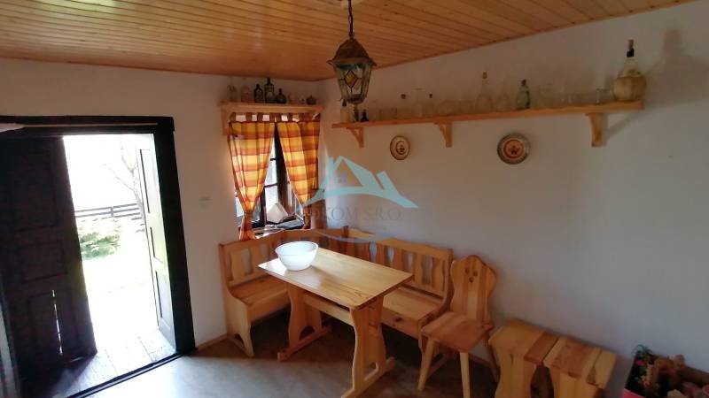 Das ländliche Interieur bietet eine Holzbank und einen Tisch, die Möbel vervollständigen die Atmosphäre eines Familienhauses.