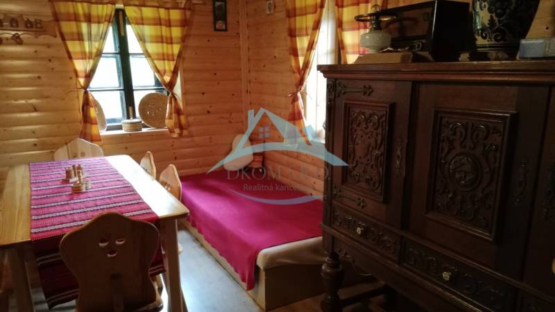 Das Innere der Blockhütte mit massiven Möbeln, Holzwänden und bunten Vorhängen in einem Einfamilienhaus.