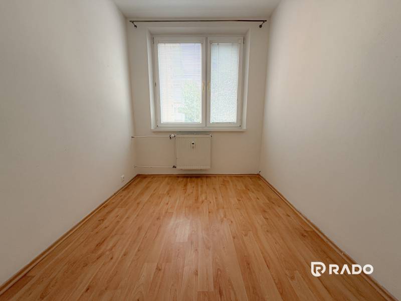 Ein leerer Raum mit Fenster und Heizkörper, Holzboden, 3-Zimmer-Wohnung.