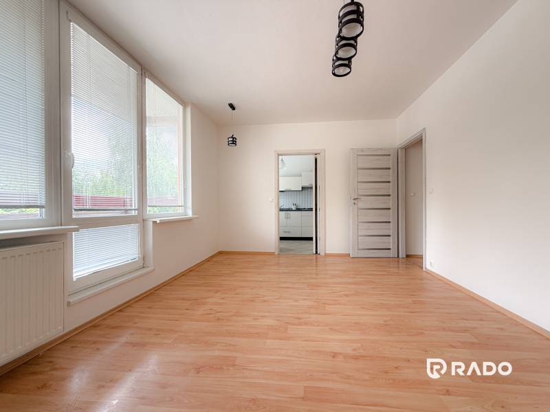 Ein geräumiges Zimmer in einer 3-Zimmer-Wohnung mit Holzboden und großen Fenstern.