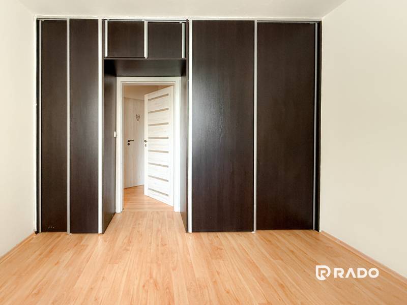 In der 3-Zimmer-Wohnung ist ein Einbauschrank mit dunklen Türen und ein Holzboden zu sehen.
