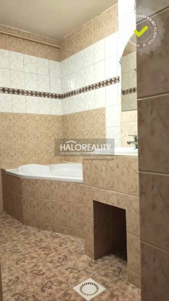 Badezimmer in einer 4-Zimmer-Wohnung mit Eckbadewanne und Keramikfliesen.