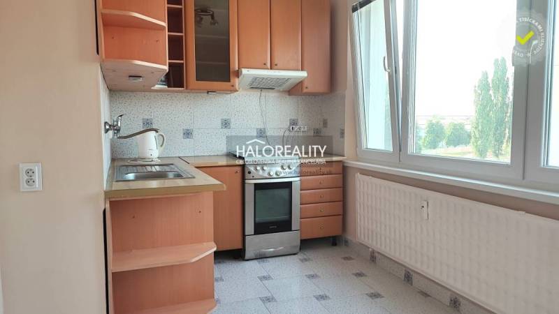 Küche in einer 4-Zimmer-Wohnung mit Holzschränken und großem Fenster.