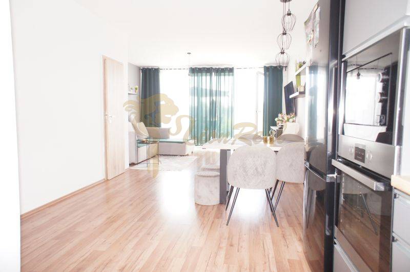 Obývací Zimmer in einem Einfamilienhaus mit Esstisch und Küchenzeile.