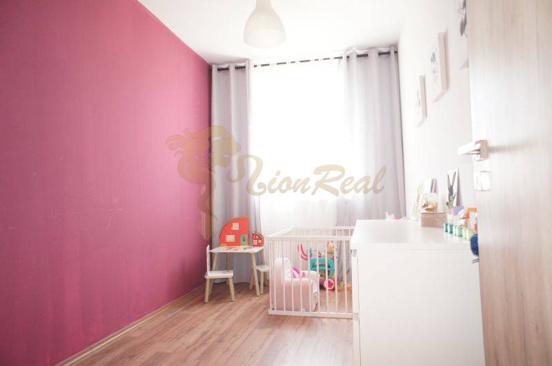 Kinderzimmer in einem Einfamilienhaus mit rosa Wand, Spielzeug und Kinderbett.