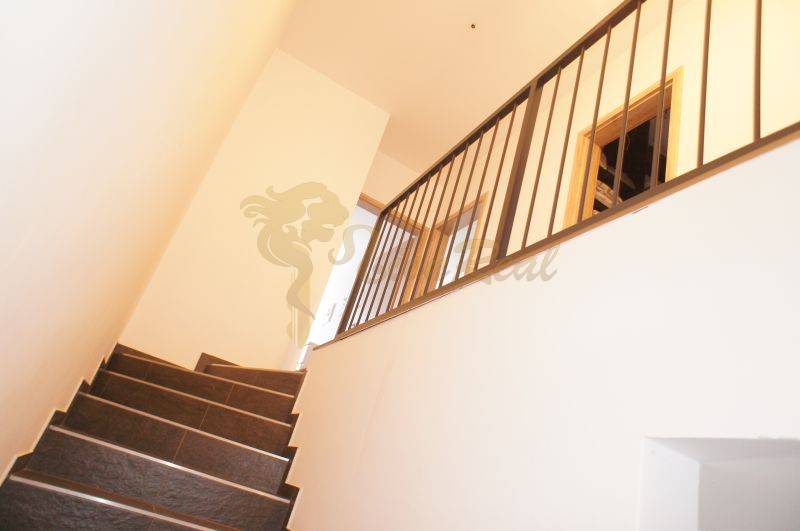 Treppe mit Metallgeländer in einem Einfamilienhaus, einfaches Interieurdesign.