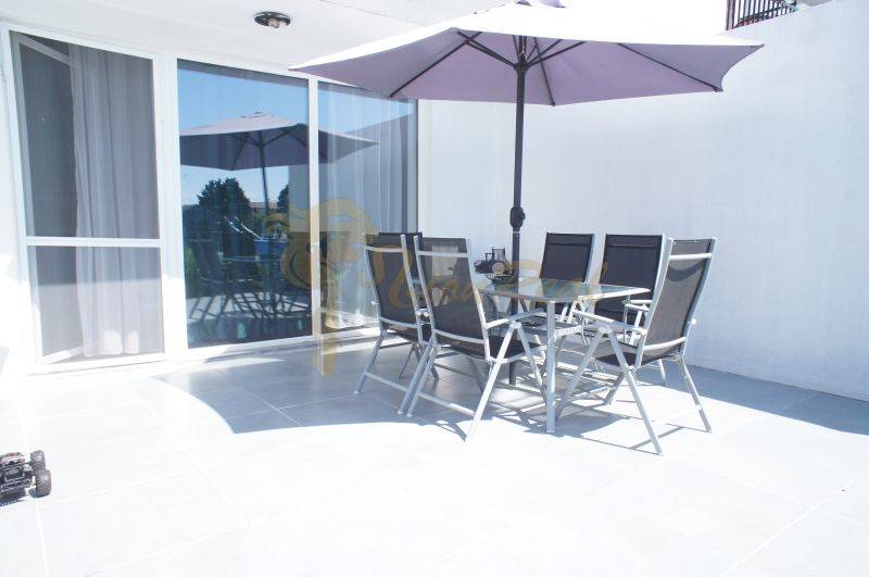 Eine Terrasse mit Sitzgelegenheiten und Sonnenschirm in einem Einfamilienhaus in der Platanová-Straße in Miloslavov.