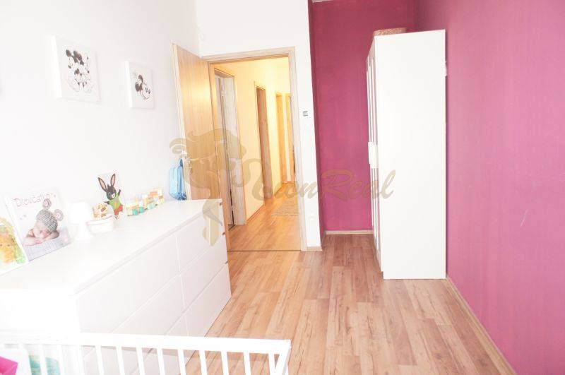 Kinderzimmer in einem Einfamilienhaus mit Holzboden und lila Wand.