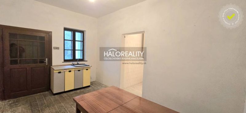 Küche in einem Einfamilienhaus mit Schrank, Tisch, Tür und Fenster.