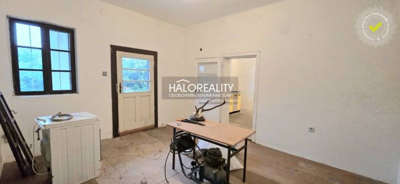 Ein Zimmer in einem Einfamilienhaus mit Holzboden, Dekor, Tisch und Geräten.