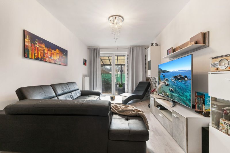 Wohnzimmer einer 3-Zimmer-Wohnung mit Ledersofa und Fernseher in der Vukovarská Straße.
