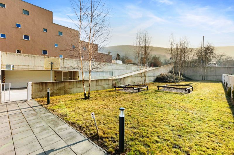 In der Vukovarská-Straße sieht man einen Garten und ein Betongebäude, ideal für eine 3-Zimmer-Wohnung.
