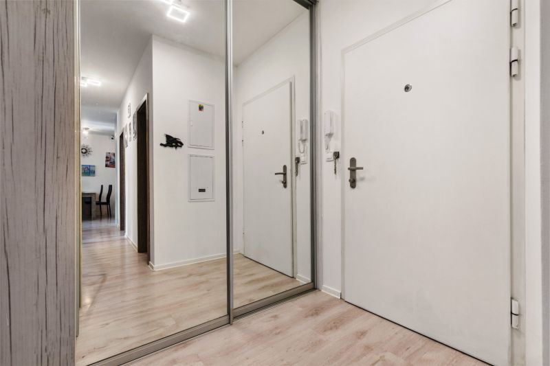 Eingangsbereich einer 3-Zimmer-Wohnung in der Vukovarská-Straße mit weißen Wänden und einem Spiegel.