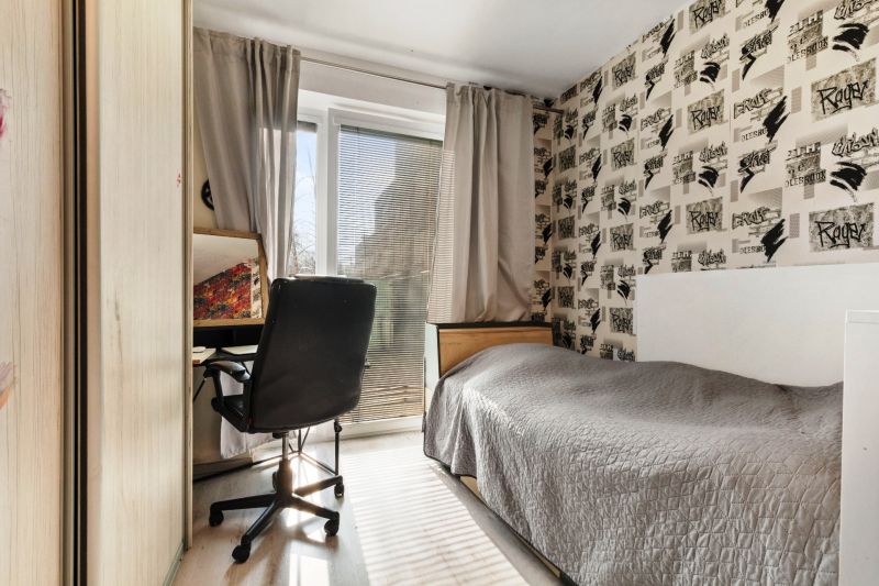 Einfaches Zimmer mit Bett und Schreibtisch in der Vukovarská-Straße, 3-Zimmer-Wohnung.