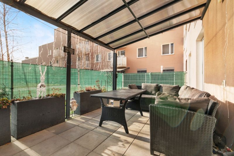 Terrasse mit Sofa und Tisch, umgeben von Pflanzen und einem Zaun an der Vukovarská-Straße.