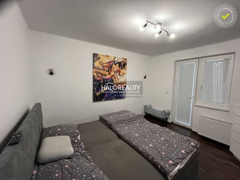 Schlafzimmer mit Bett und Bild, Zugang zum Garten durch das Fenster, Einfamilienhaus.