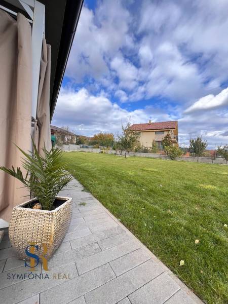 Der Garten des Einfamilienhauses in der Lipová-Straße in Dubová mit Rasen und gepflastertem Gehweg.