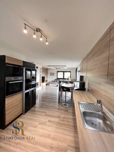 Küche in einem Einfamilienhaus mit Holzboden und praktischer Sitzgelegenheit.