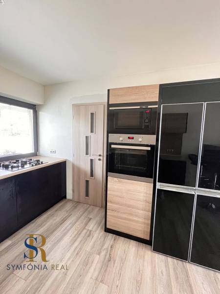 Küche in einem Einfamilienhaus mit einem Gasherd und Geräten, Boden mit Holzdekor.