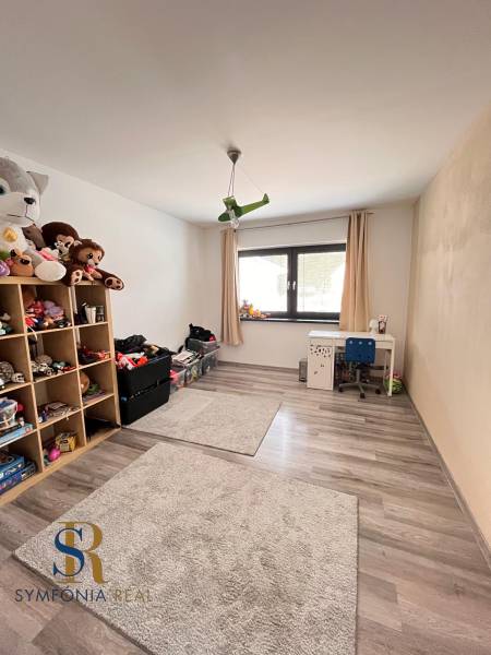 Kinderzimmer mit Spielzeug, Tisch und Holzboden in einem Einfamilienhaus.