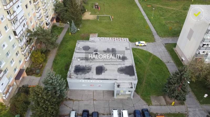 Gewerberäume in Rimavská Sobota mit Flachdach, umgeben von Grünflächen und Wohnblöcken.