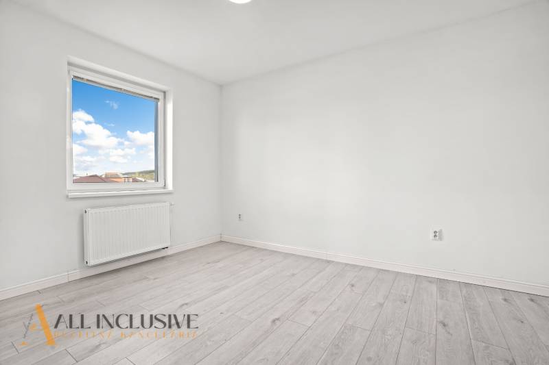 Zimmer in einer 2-Zimmer-Wohnung mit Fenster und Boden in Holzoptik.