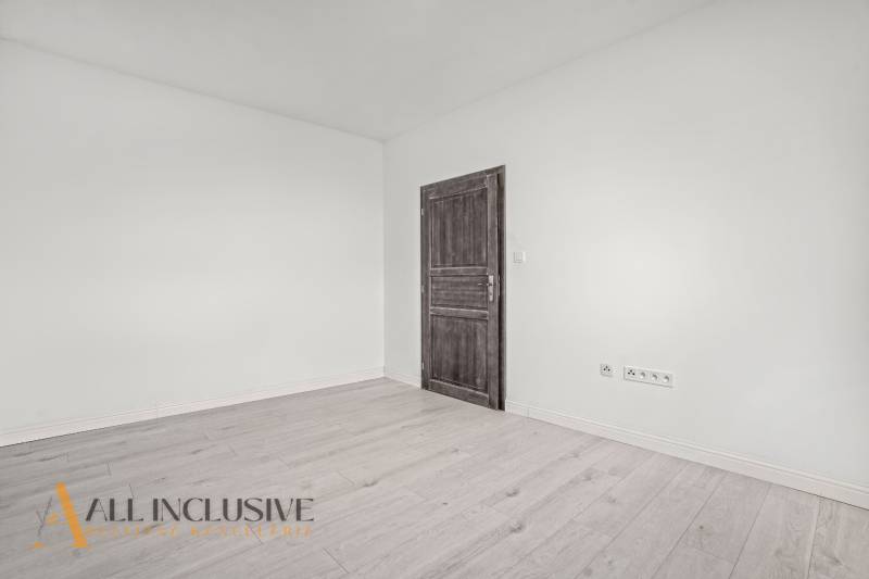 Innenraum einer 2-Zimmer-Wohnung mit weißen Wänden und einem Boden in Holzoptik.