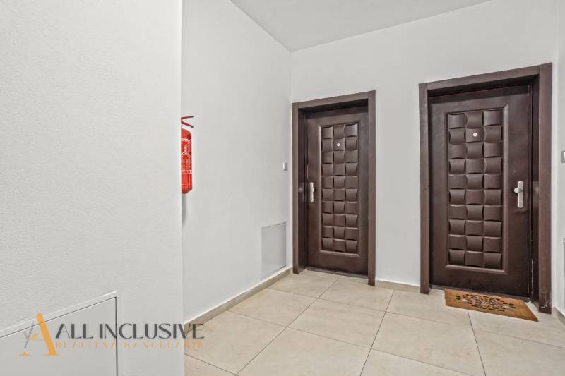 Ein Flur mit zwei Türen und einem Feuerlöscher in einer Zweizimmerwohnung.