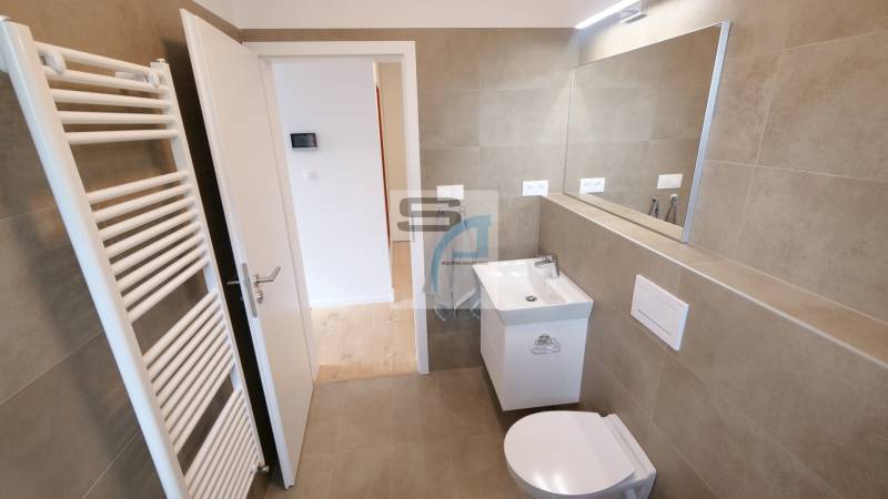 Badezimmer in einer 2-Zimmer-Wohnung mit Toilette, Waschbecken und Spiegel.