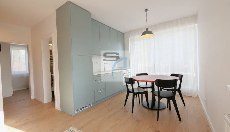 Essbereich mit Tisch und Stühlen, Einbauschränken und einem Boden mit Holzdekor.