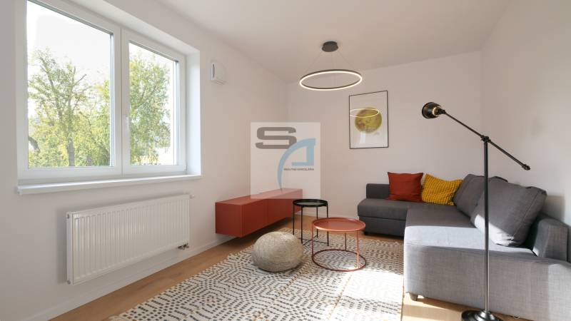 Wohnzimmer in einer 2-Zimmer-Wohnung, Sitzgelegenheit, bunte Kissen, Couchtische, Teppich.