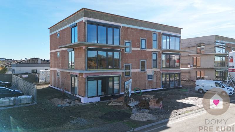 Neubau in der Dúhová-Straße in Slovenský Grob mit verglasten Wänden und Parkplatz.