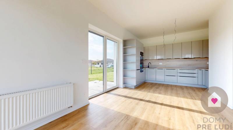 Küche und Wohnbereich in einer 3-Zimmer-Wohnung mit großen Fenstern und Blick ins Grüne.