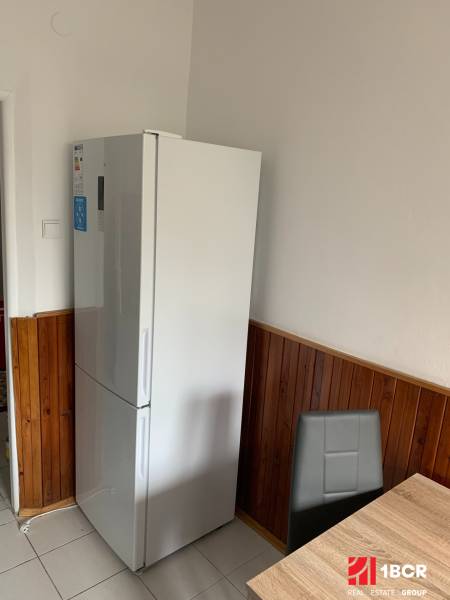Küche in einer 2-Zimmer-Wohnung mit Kühlschrank, geflieste Wände, Keramikboden.