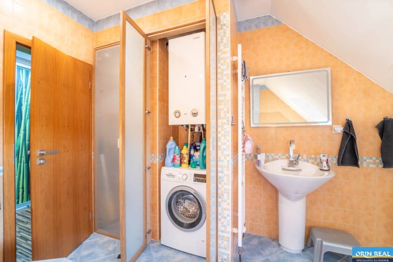 Badezimmer in einer 2-Zimmer-Wohnung mit Waschmaschine, Gasheizung und Waschbecken.
