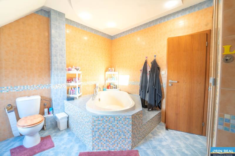 Badezimmer mit Eckbadewanne und bunten Fliesen in einer 2-Zimmer-Wohnung.