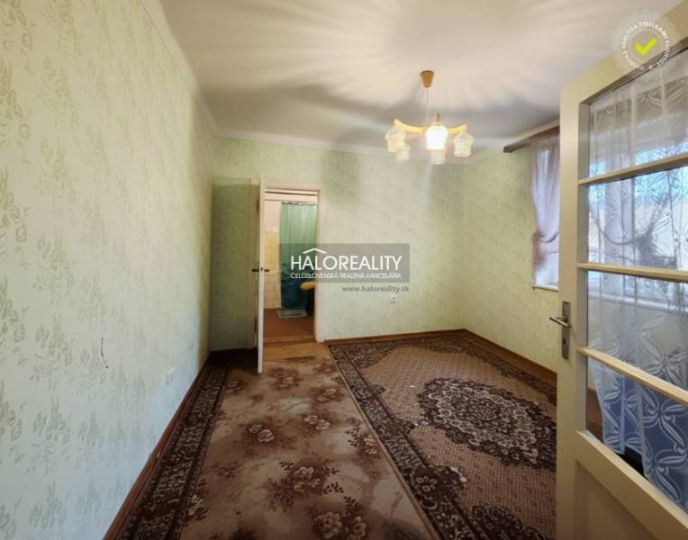 Ein Zimmer in einem Einfamilienhaus mit Teppichboden, grünen Wänden und dekorativer Beleuchtung.