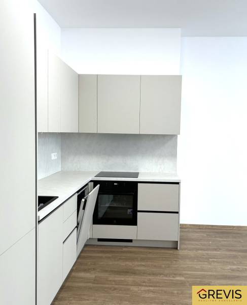 Küche in einer 4-Zimmer-Wohnung mit Holzboden und weißen Schränken.