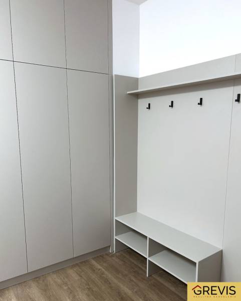 Einbauschrank mit Bank und Haken in einer 4-Zimmer-Wohnung, Boden mit Holzdekor.