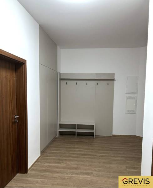 Eingangsbereich einer 4-Zimmer-Wohnung mit weißen Wänden und einem Boden in Holzoptik.